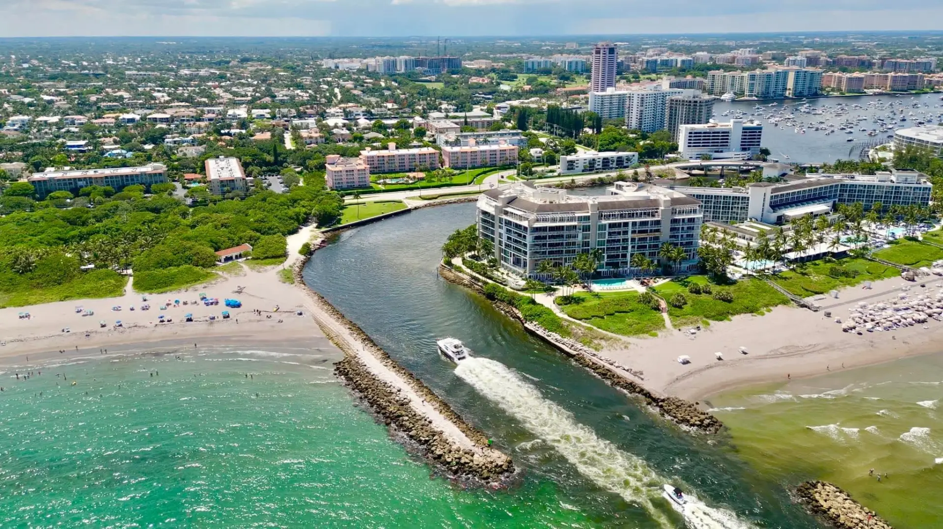 Aerial view of the Boca Raton inlet with a boat heading out to the turquoise Atlantic
